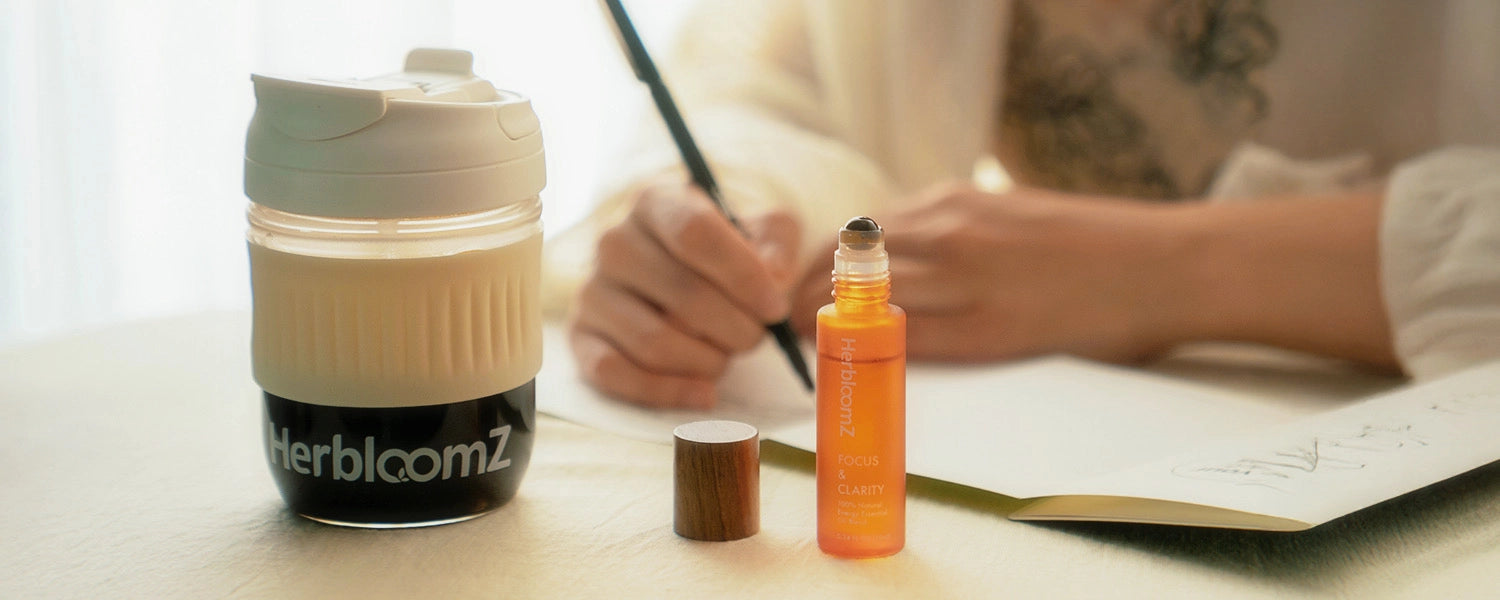 HerbloomZ SUPERBA Coffee Wellness Cup and Focus Essential Oil on desk beside open journal — ritual step 3 enjoy calm focus