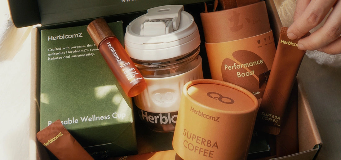 HerbloomZ SUPERBA Coffee gift set with mushroom coffee tin, pouch, sachets, Focus Essential Oil, and Wellness Cup in a sunlit box presentation