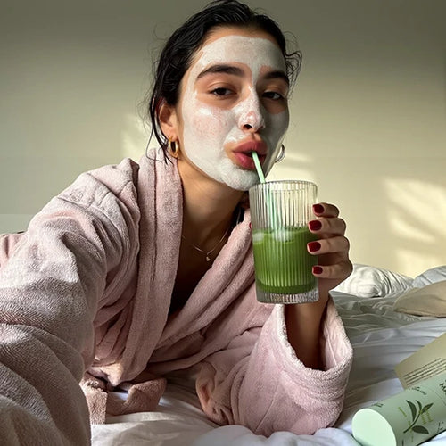 A customer enjoying a self-care moment with a face mask and a glass of HerbloomZ SUPERBA probiotic matcha, representing a positive review