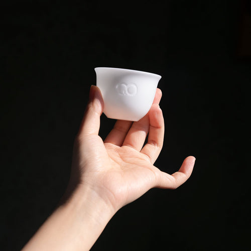 Hand holding a HerbloomZ candle made from Dehua porcelain, showing minimalist design and fine translucency - HerbloomZ