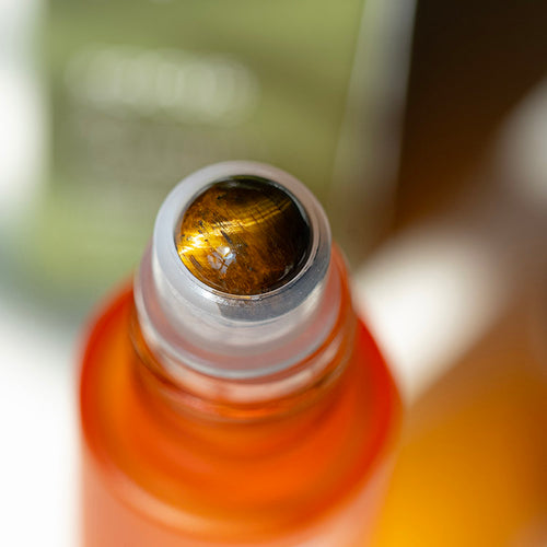 Close-up of Tiger’s Eye gemstone roller on HerbloomZ Focus & Clarity essential oil bottle, showing the natural golden-brown stone in detail. - HerbloomZ
