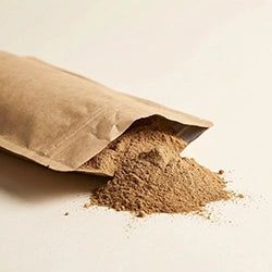 Brown paper bag with its contents spilling out onto a light beige background