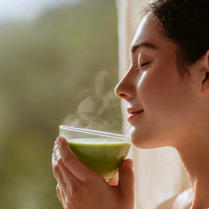 Woman holding a steaming superba matcha in a blurred natural setting